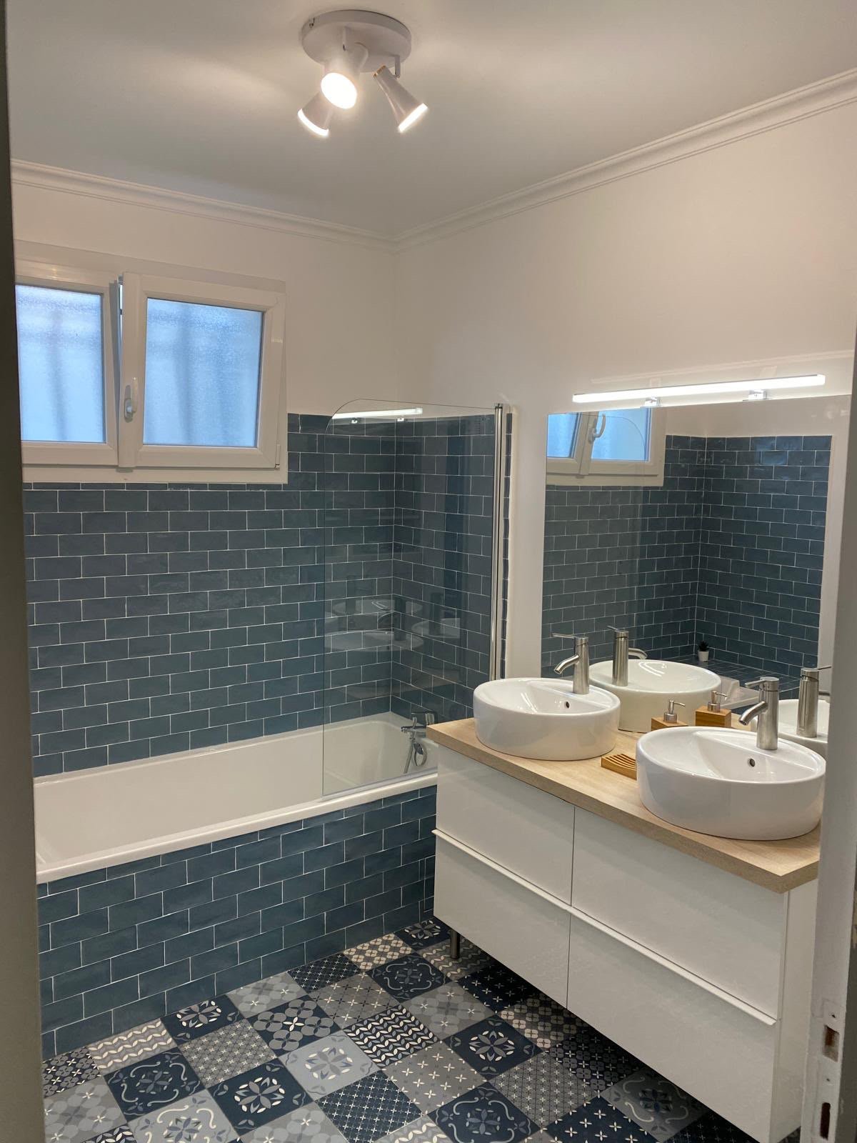 Salle de bains carrelage métro bleu et sol à motifs